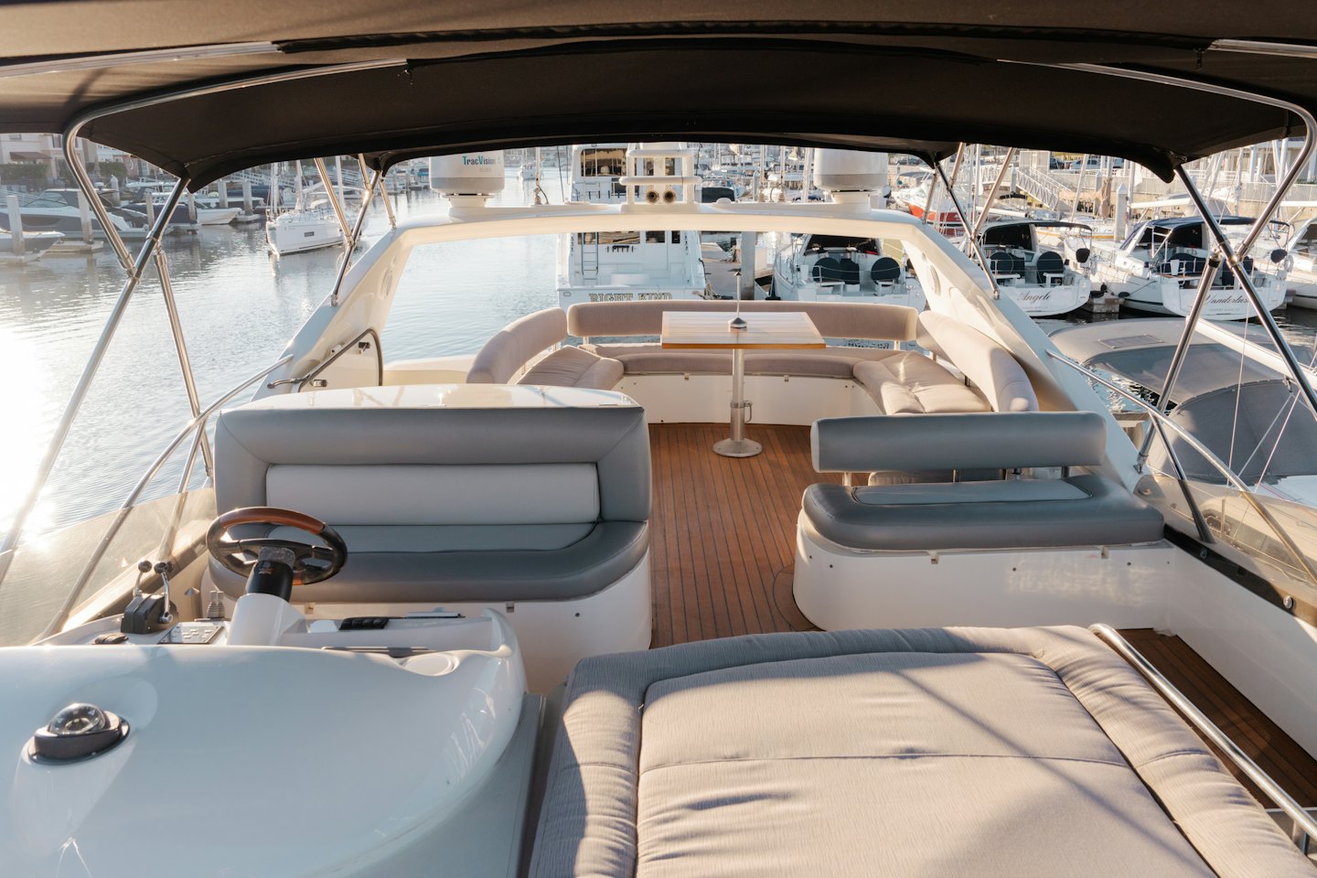 Modern yacht cockpit with upholstered seating docked at a marina.