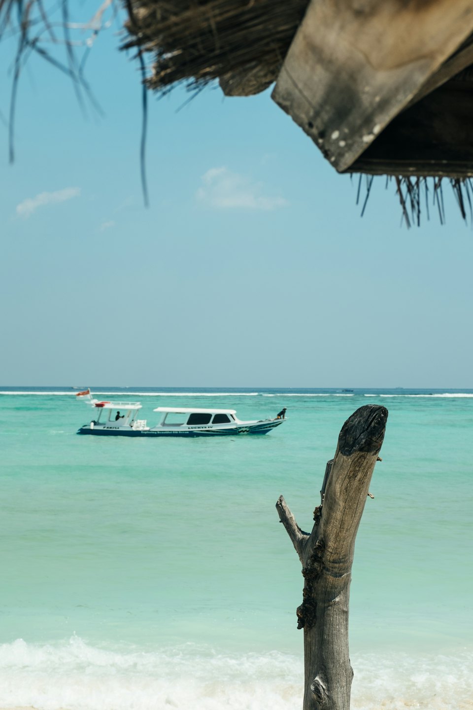Speedboat on turquoise water under a blue sky.
